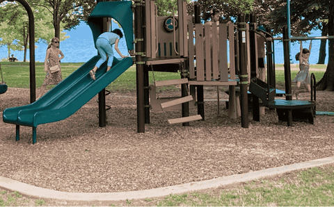 A swing set on wood chips.