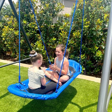 Two kids on a blue swing.