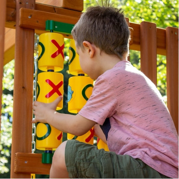 A young boy playing on a tic-toe-panel.