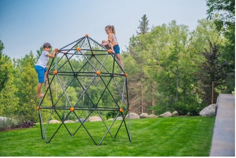 Two kids playing on a geometric climbing dome.
