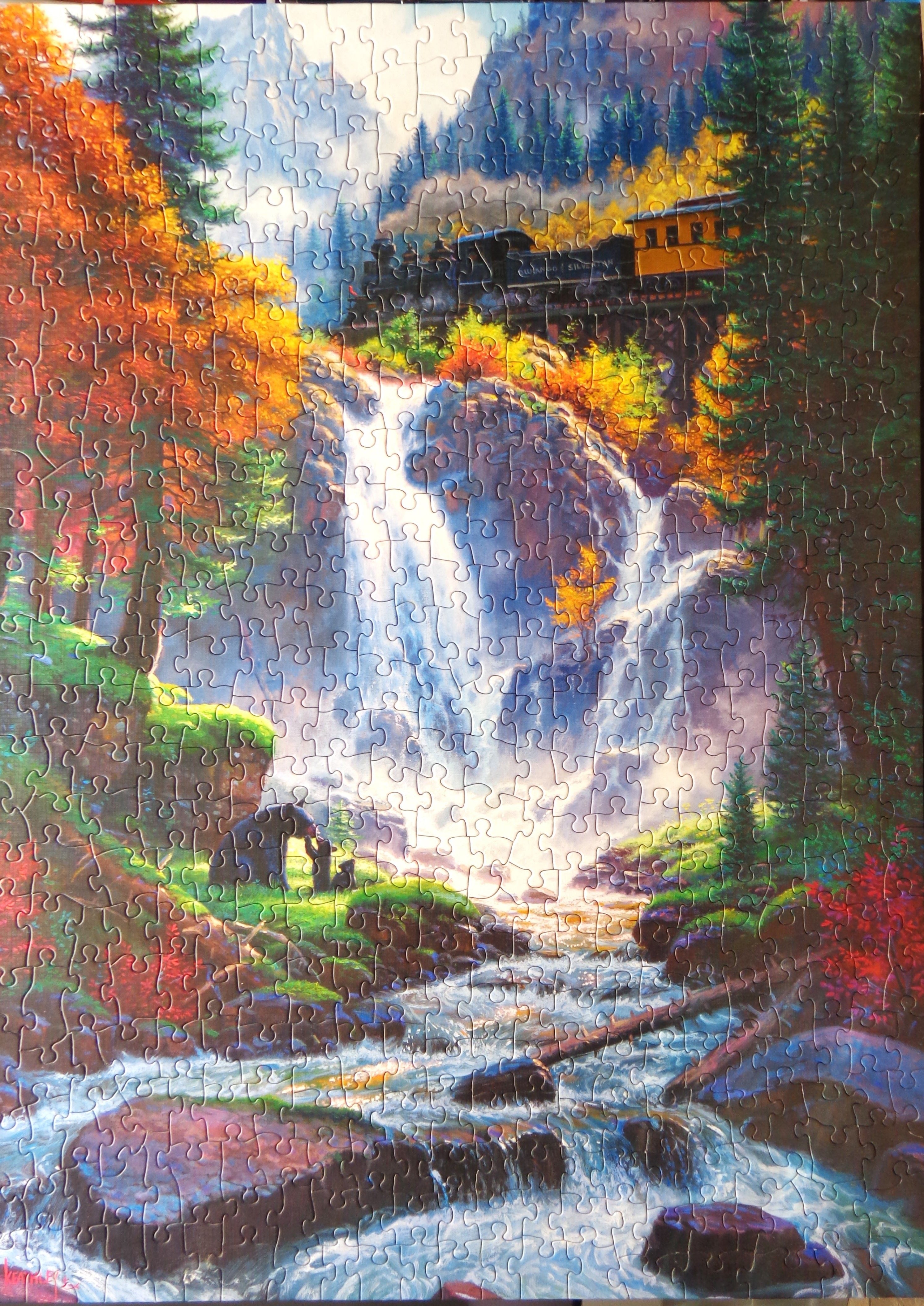 Waterfall with a train passing through mountain side