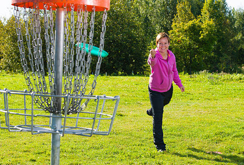a woman playing disc golf