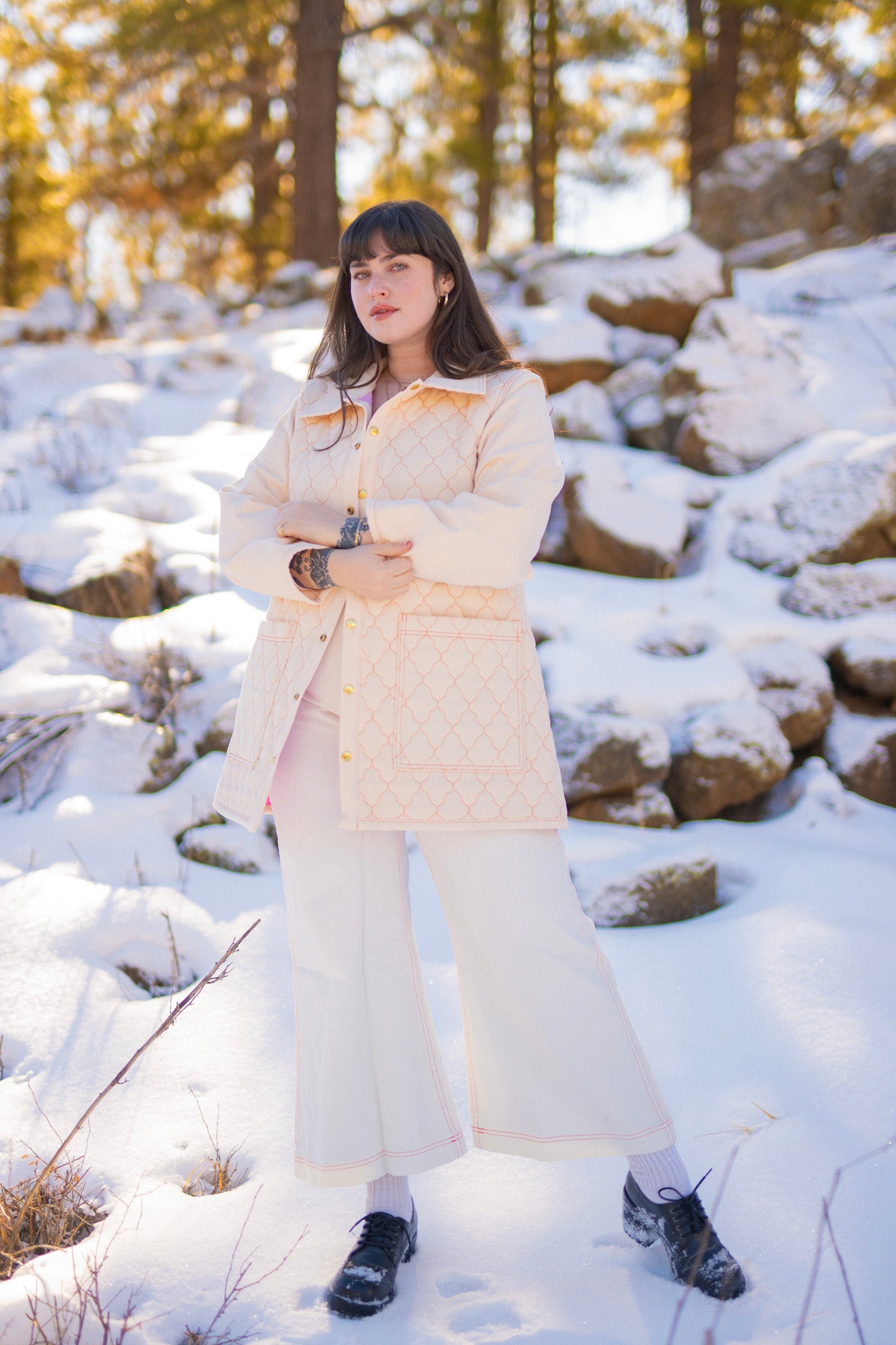 Sydney is wearing Quilted Overcoat in Vintage Off-White, Long Sleeve V-Neck Tee in Vintage Off-White and Bell Bottoms in Vintage Off-White