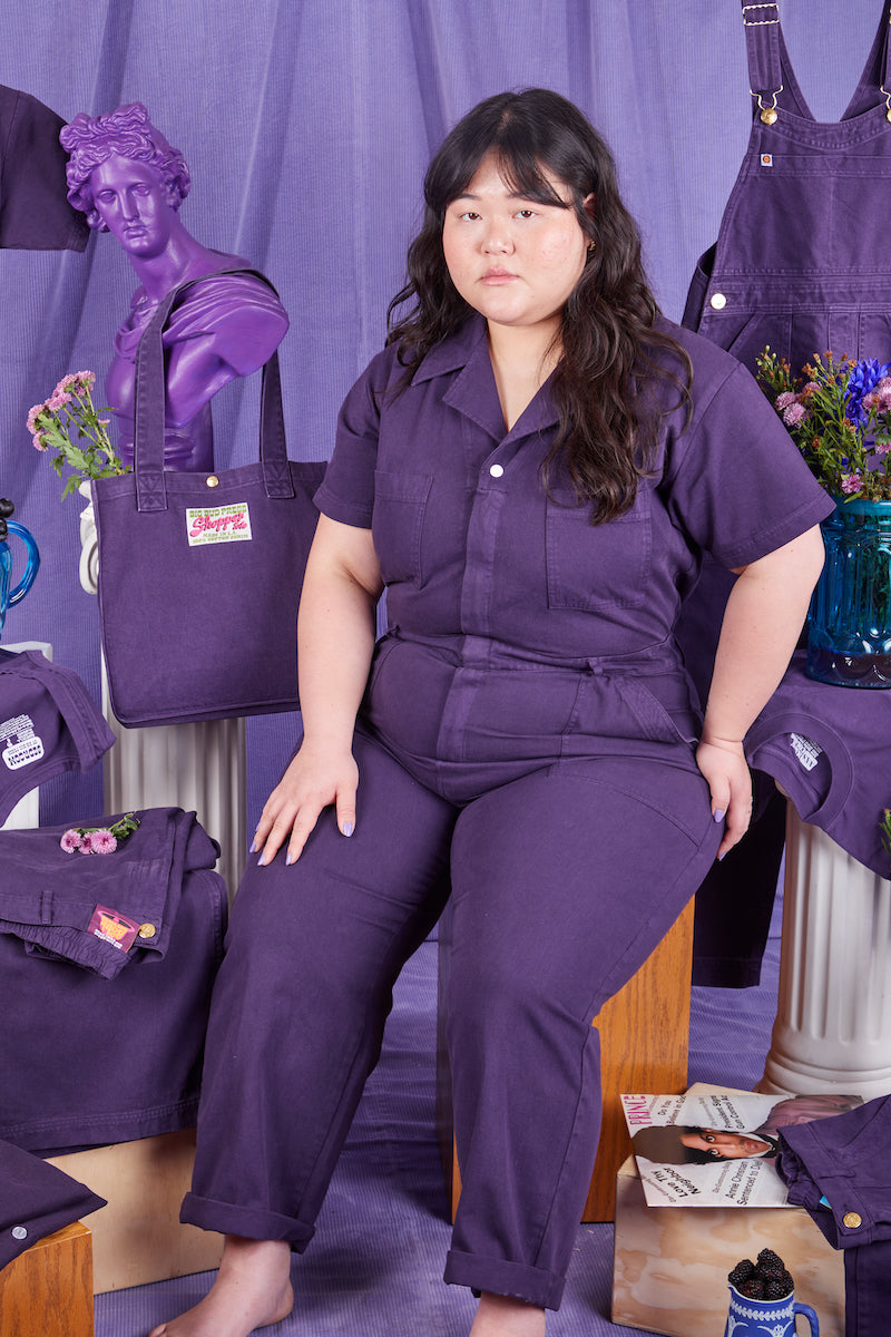 Ashley is wearing a Short Sleeve Jumpsuit in Nebula. Items from the Nebula collection surround Ashley