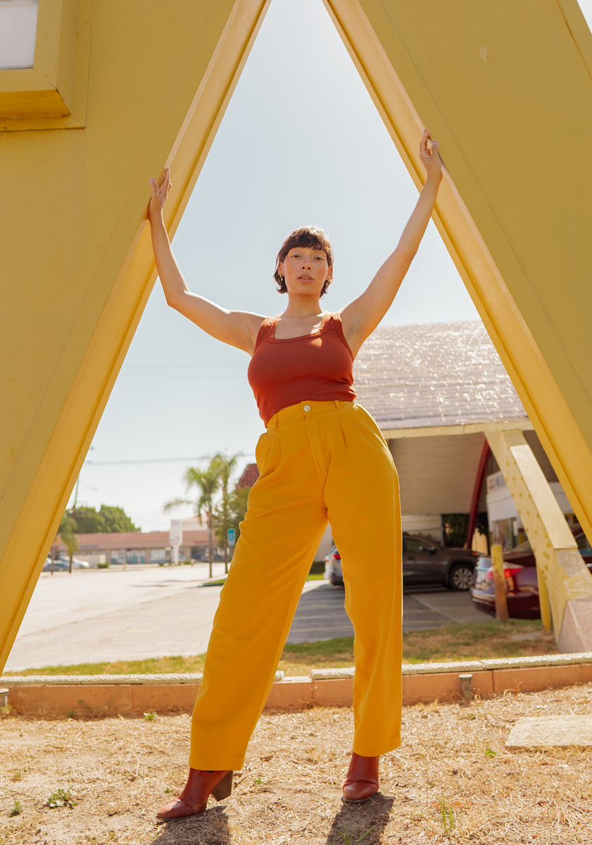 Tiara is wearing Cropped Tank Top in Burnt Terracotta and Organic Trousers in Mustard Yellow