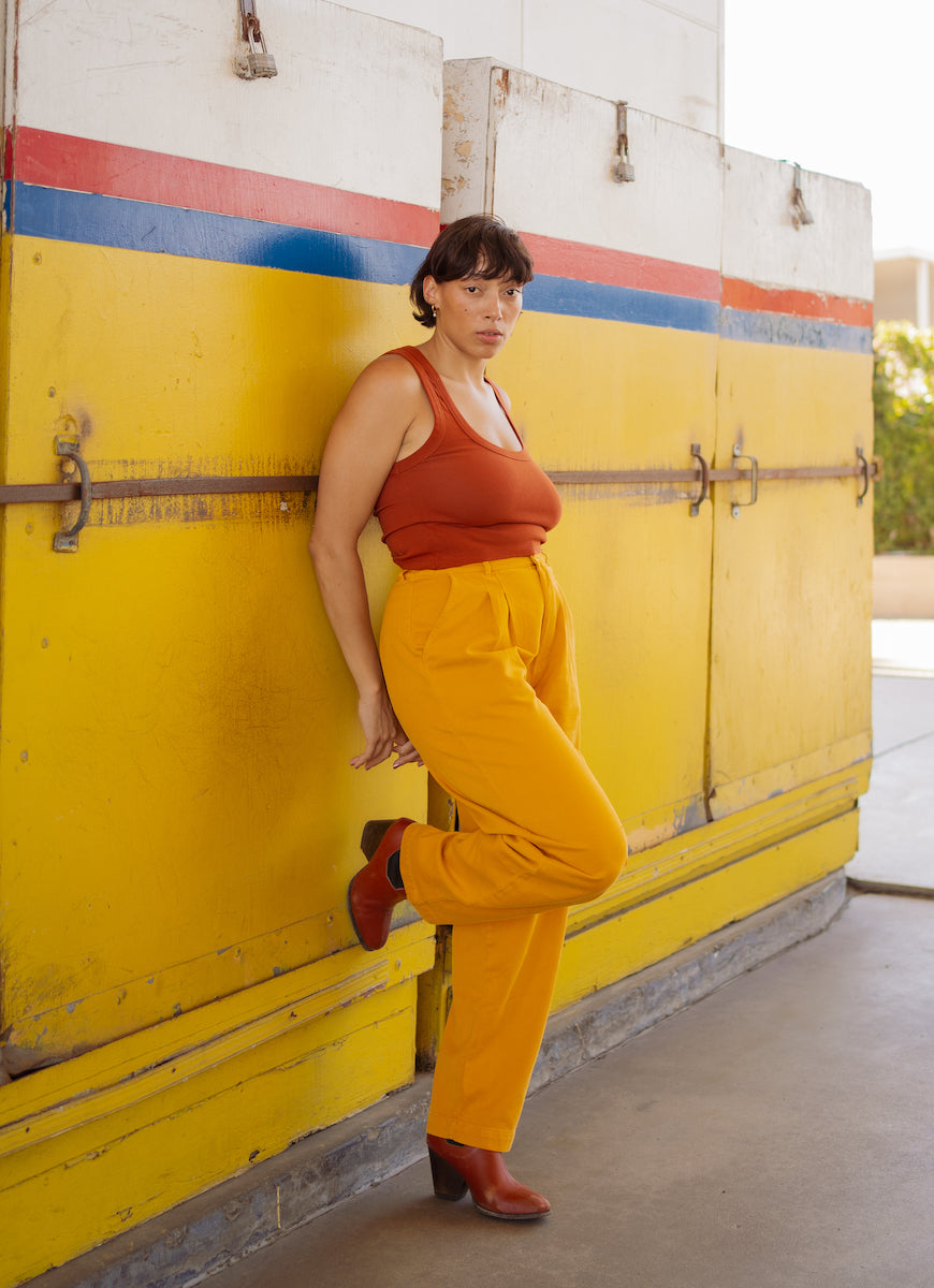 Tiara is wearing Cropped Tank Top in Burnt Terracotta and Organic Trousers in Mustard Yellow