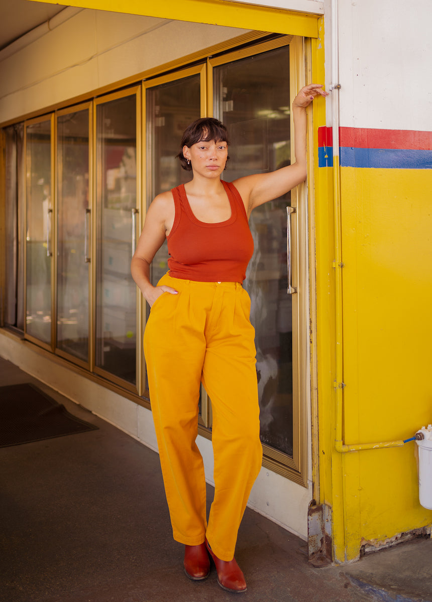 Tiara is wearing Cropped Tank Top in Burnt Terracotta and Organic Trousers in Mustard Yellow