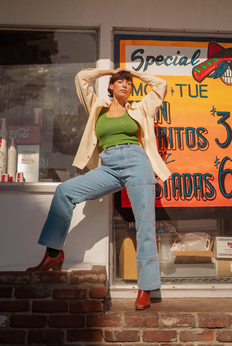 Tiara is wearing Oversize Overshirt in Vintage Off-White, Cropped Tank Top in Lawn Green, and Carpenter Jeans in Light Wash