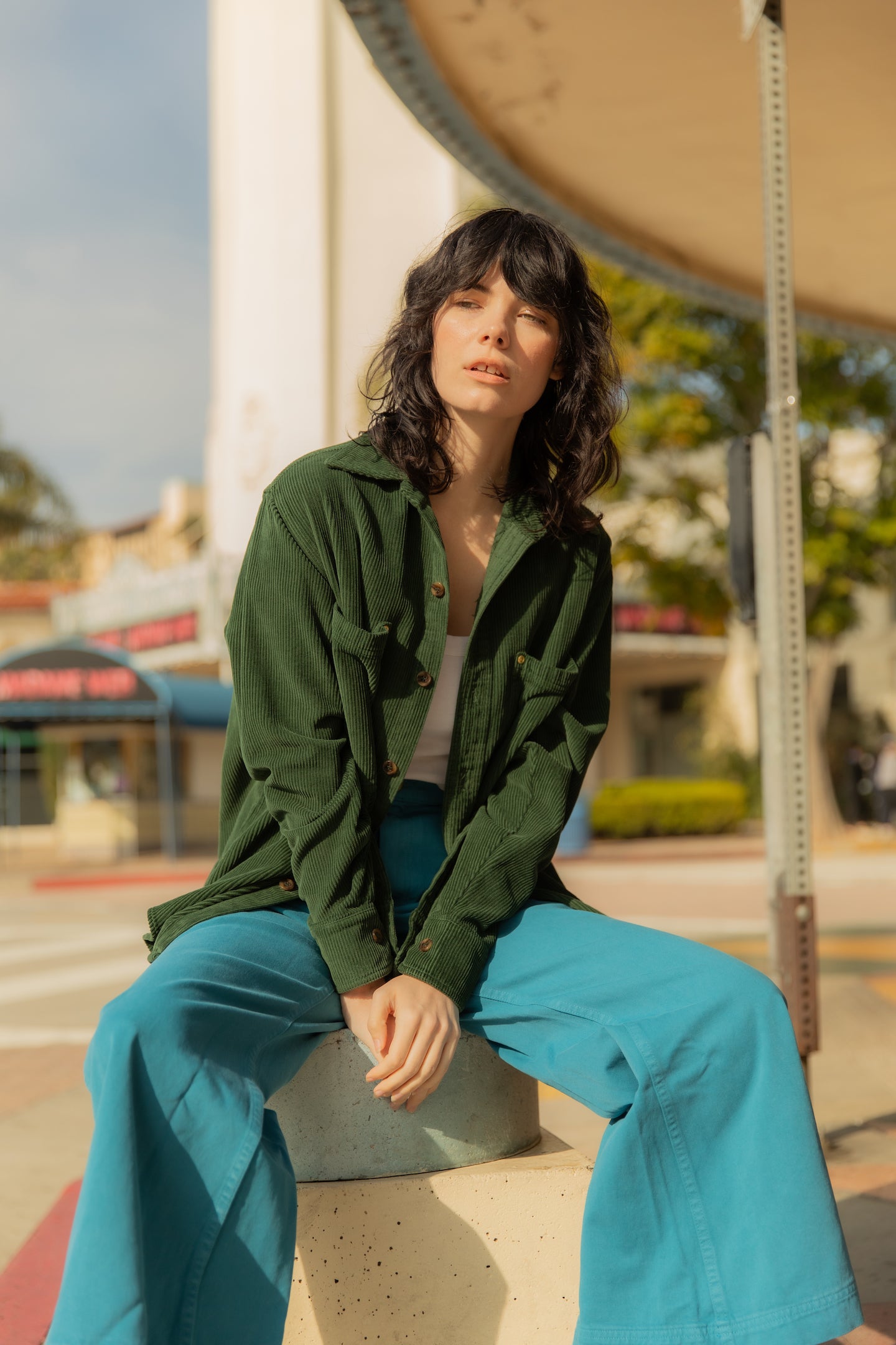 Dani is wearing Corduroy Overshirt in Swamp Green, Cropped Cami in Vintage Off-White and Bell Bottoms in Marine Blue