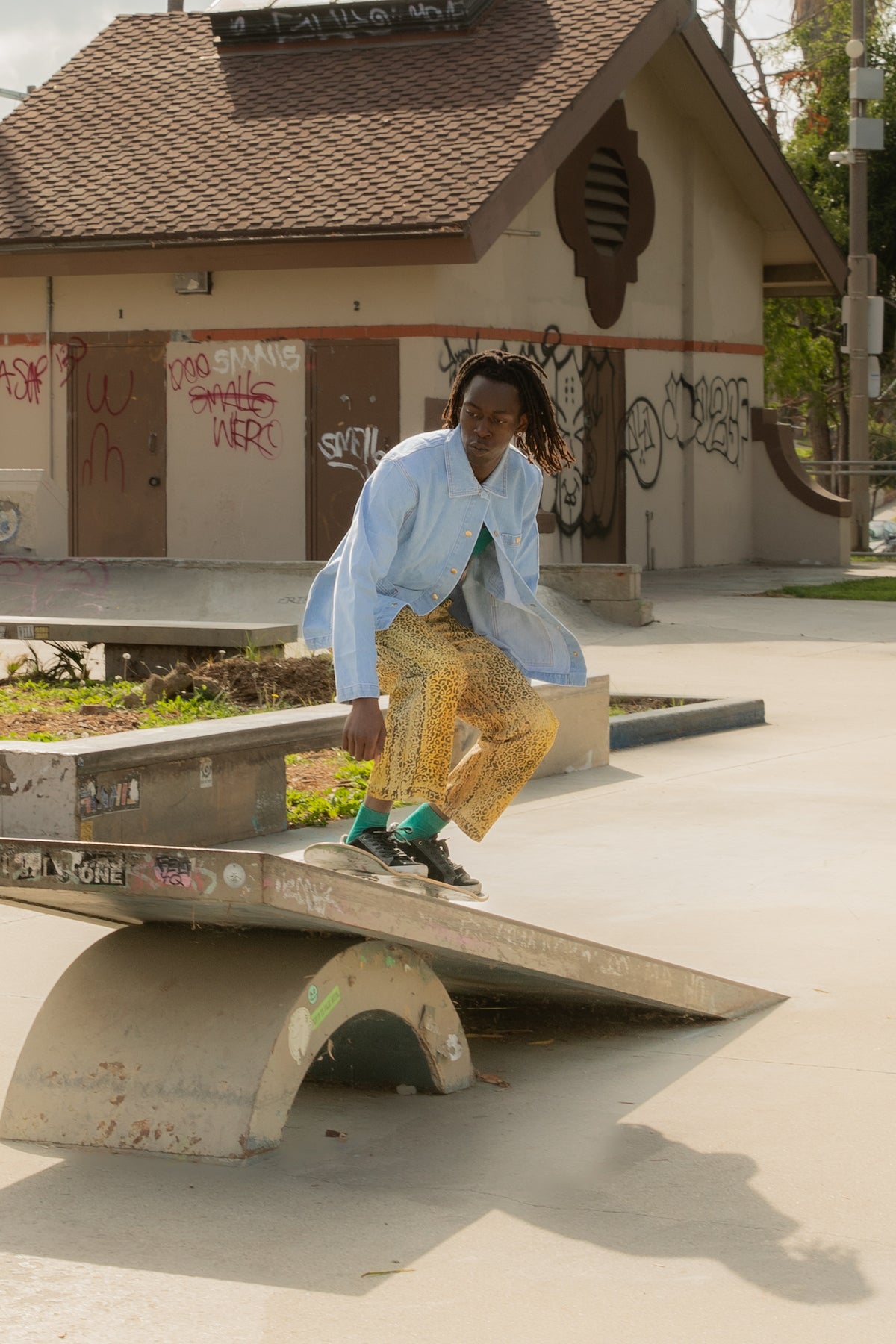 Malcom is wearing Leopard Work Pants, Indigo Denim Work Jacket in Light Wash, and Cropped Tank Top in Hunter Green