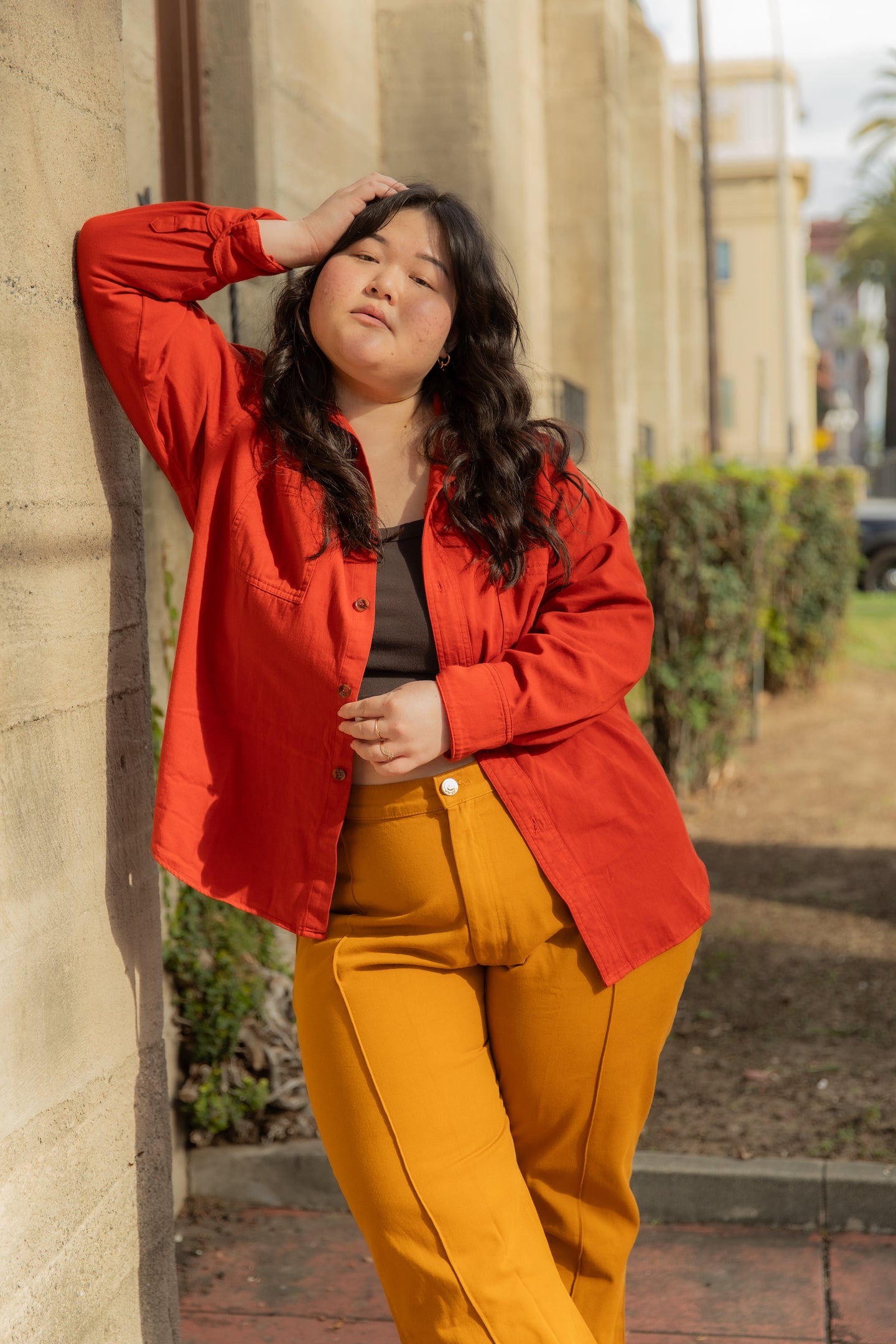Ashley is wearing Oversize Overshirt in Paprika, Cropped Tank Top in Espresso Brown and Western Pants in Spicy Mustard