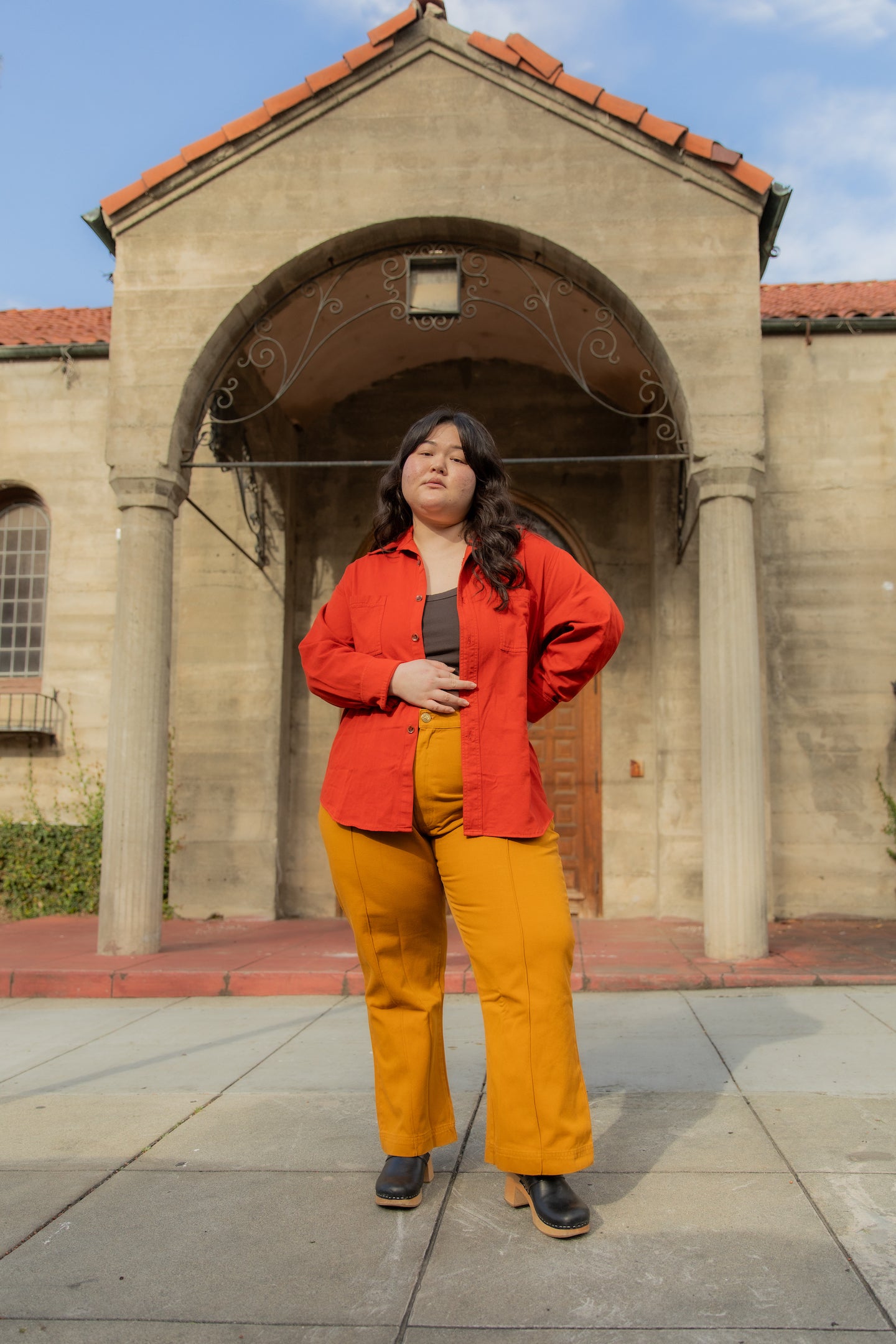 Ashley is wearing Oversize Overshirt in Paprika, Cropped Tank Top in Espresso Brown and Western Pants in Spicy Mustard