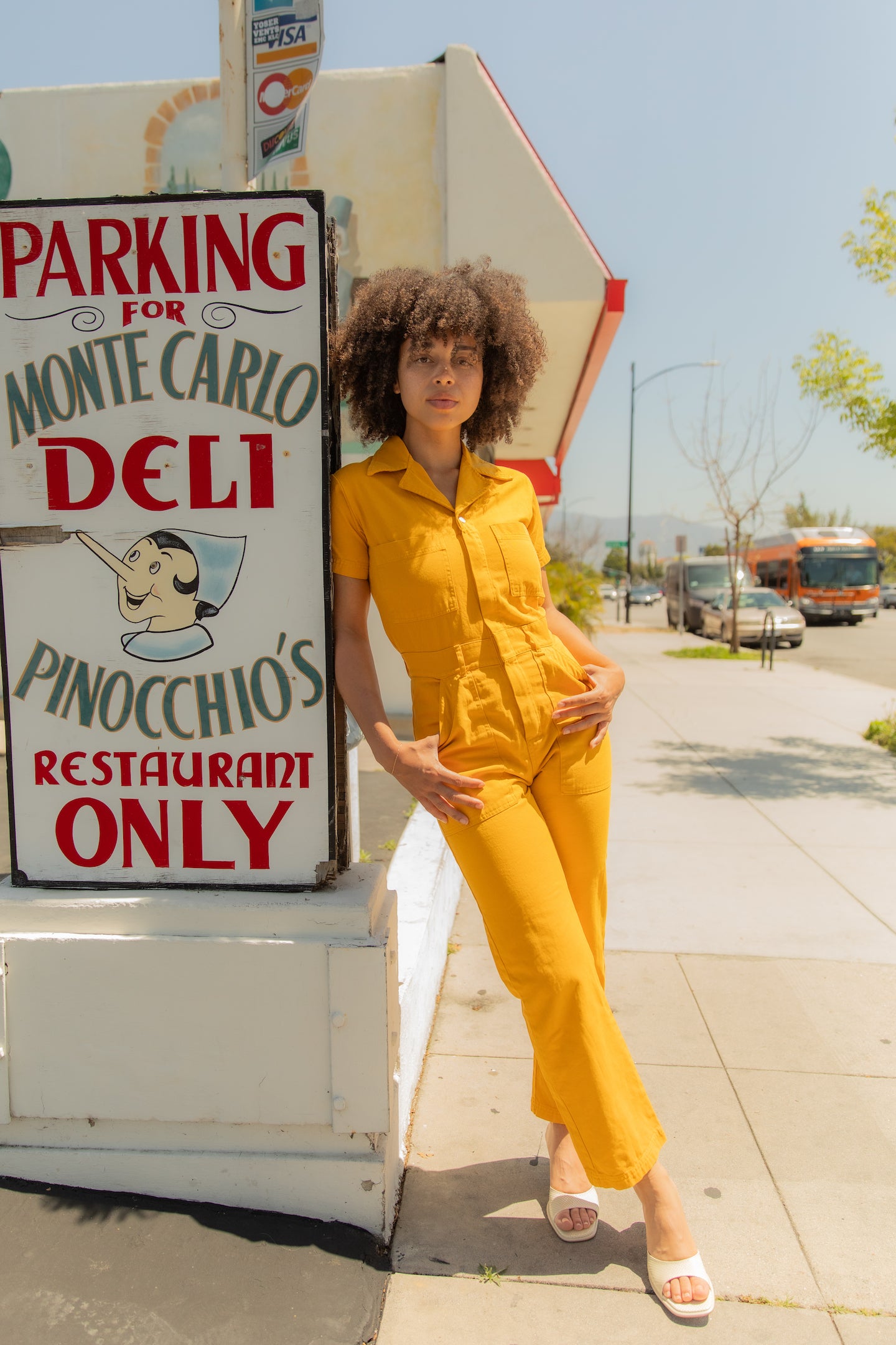 Gabi is wearing Short Sleeve Jumpsuit in Mustard Yellow