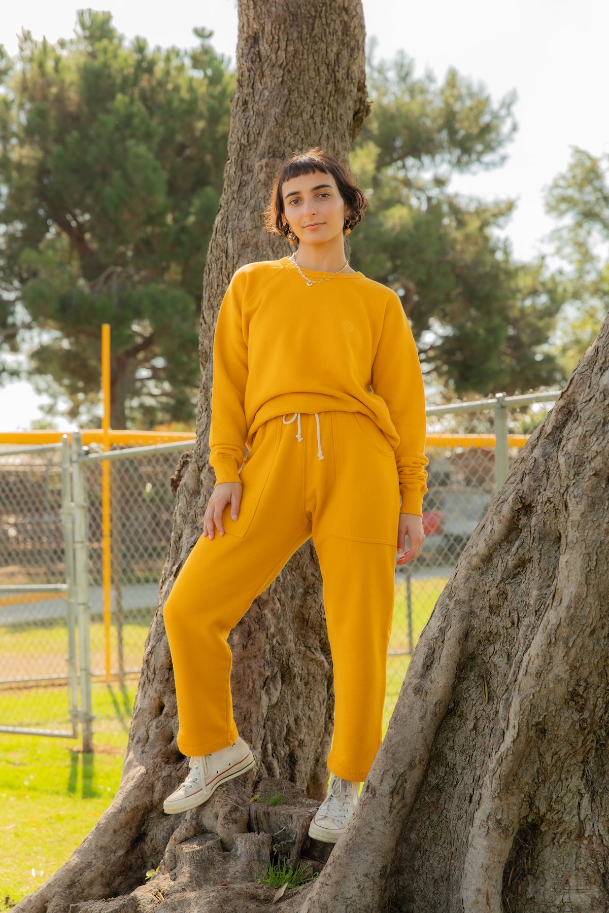 Soraya is wearing Heavyweight Crew in Sunshine Yellow and Cropped Rolled Cuff Sweatpants in Sunshine Yellow