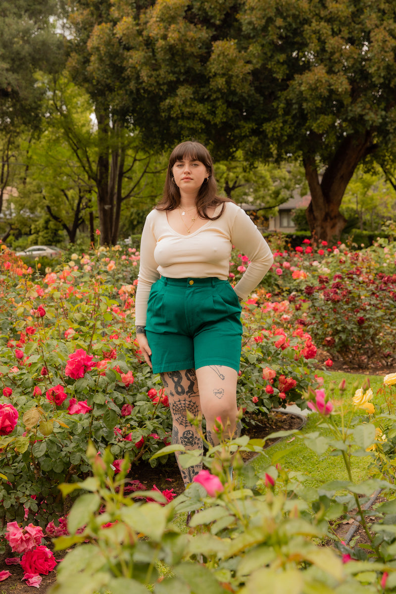 Sydney is wearing Long Sleeve V-Neck Tee in Vintage Off-White and Trouser Shorts in Hunter Green
