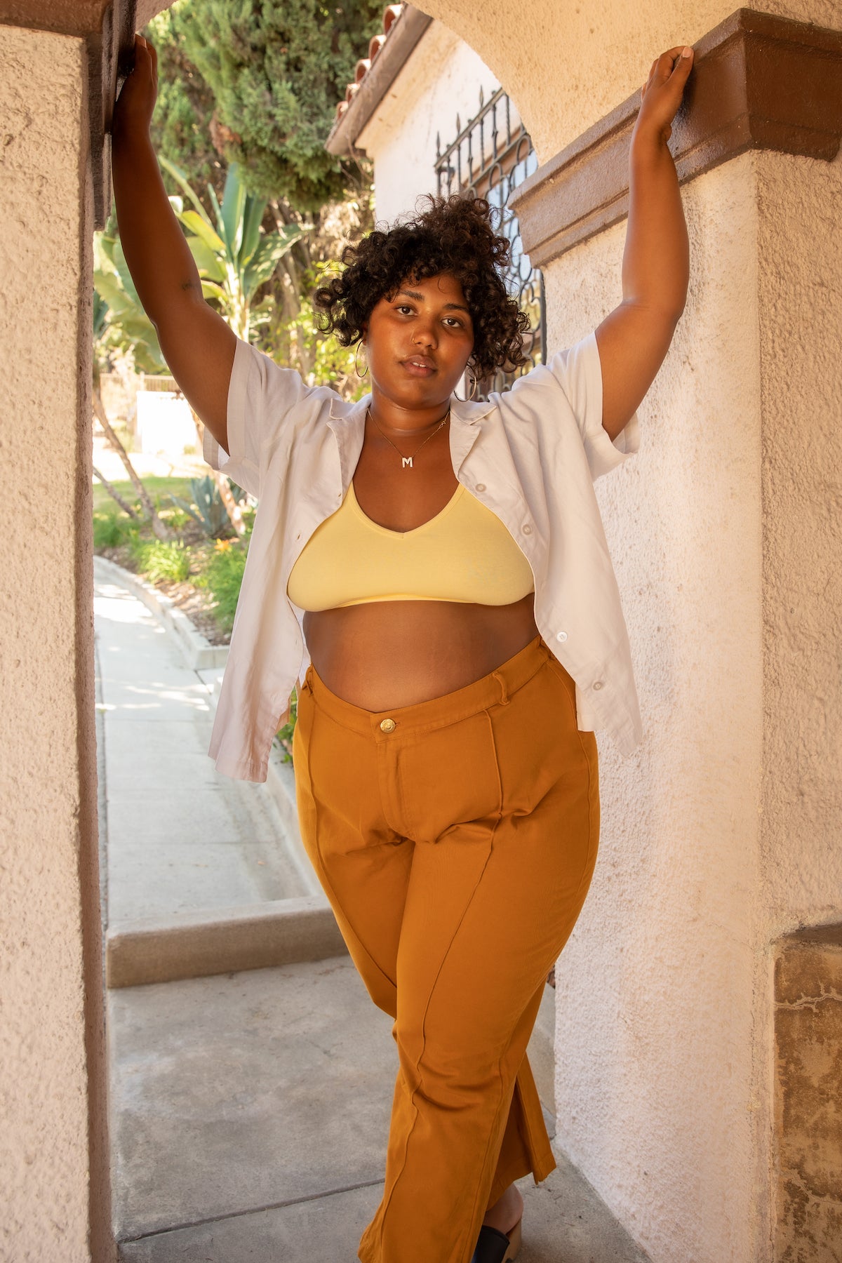 Morgan is wearing Pantry Button-Up in Vintage Off-White, Bralette in Butter Yellow, and Western Pants in Spicy Mustard