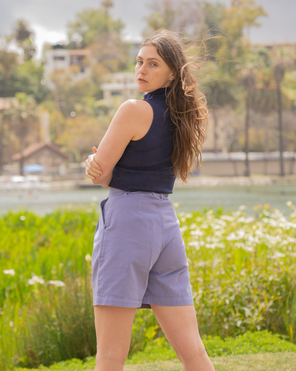 Allison is wearing Sleeveless Essential Turtleneck in Navy Blue and Trouser Shorts in Faded Grape