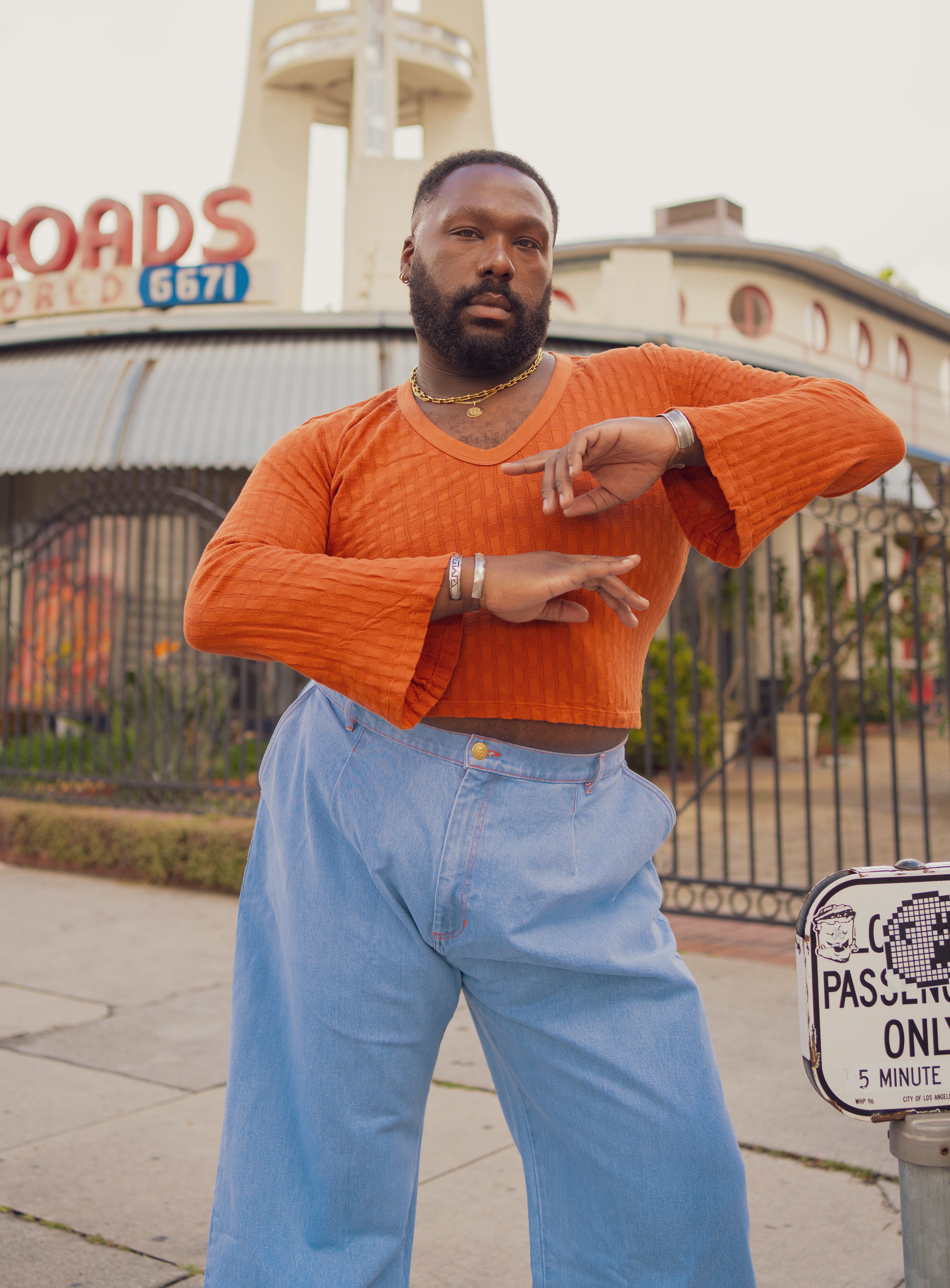 Elijah is wearing Bell Sleeve Top in Burnt Terracotta and Denim Trouser Jeans in Light Wash