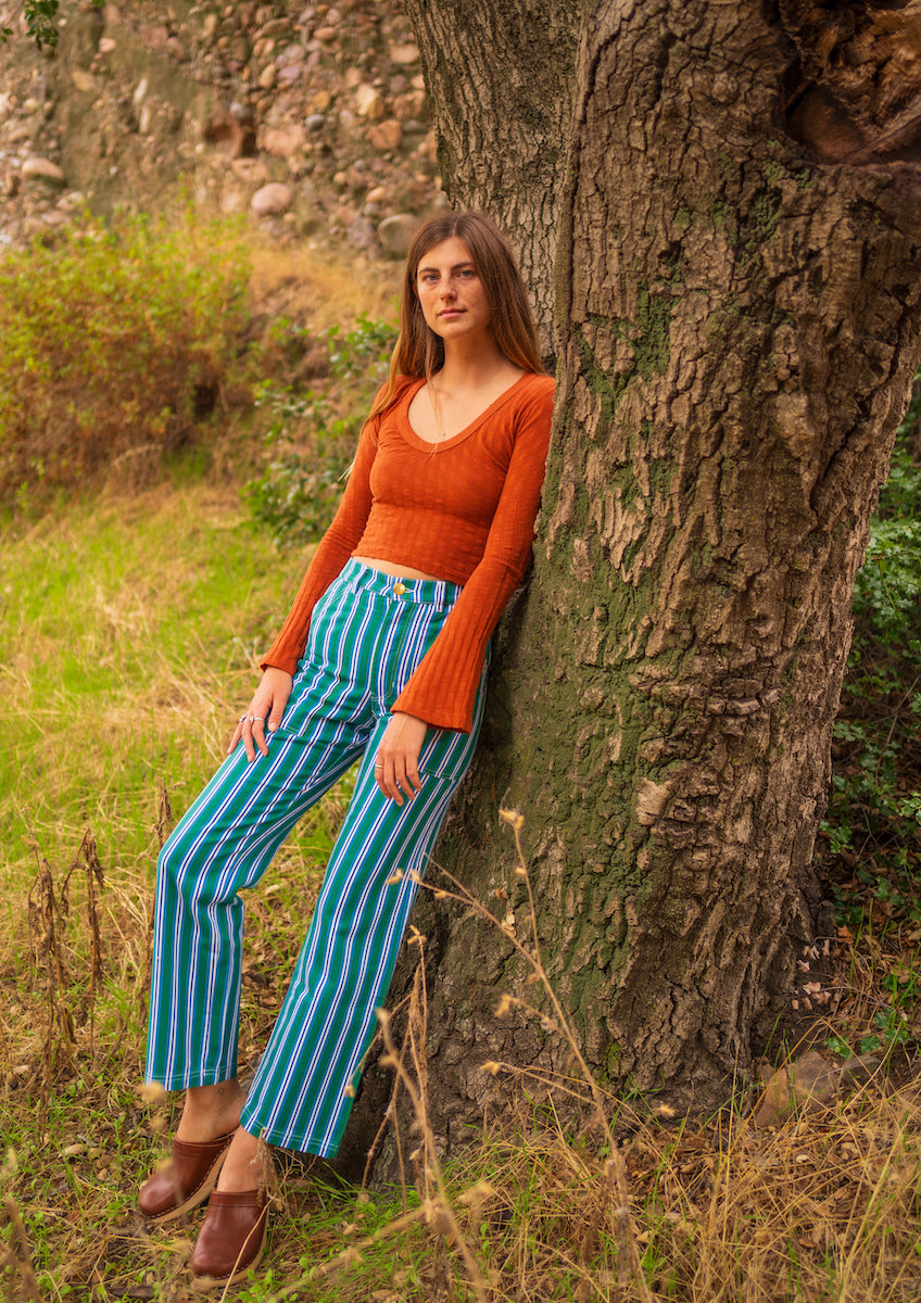 lett is wearing Bell Sleeve Top in Burnt Terracotta and Striped Work Pants in Blue