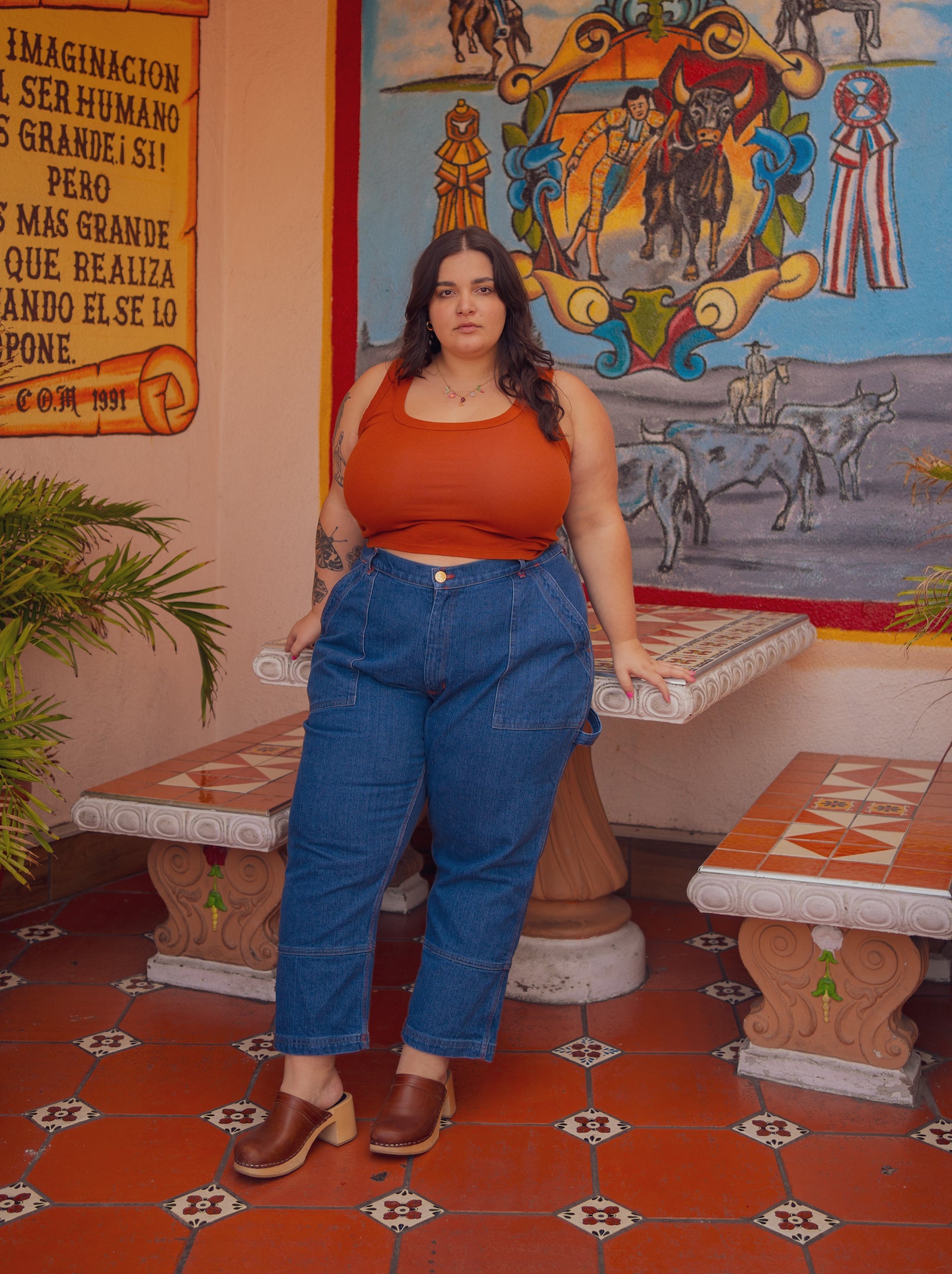 Carmen is wearing Cropped Tank Top in Burnt Terracotta and Carpenter Jeans in Dark Wash