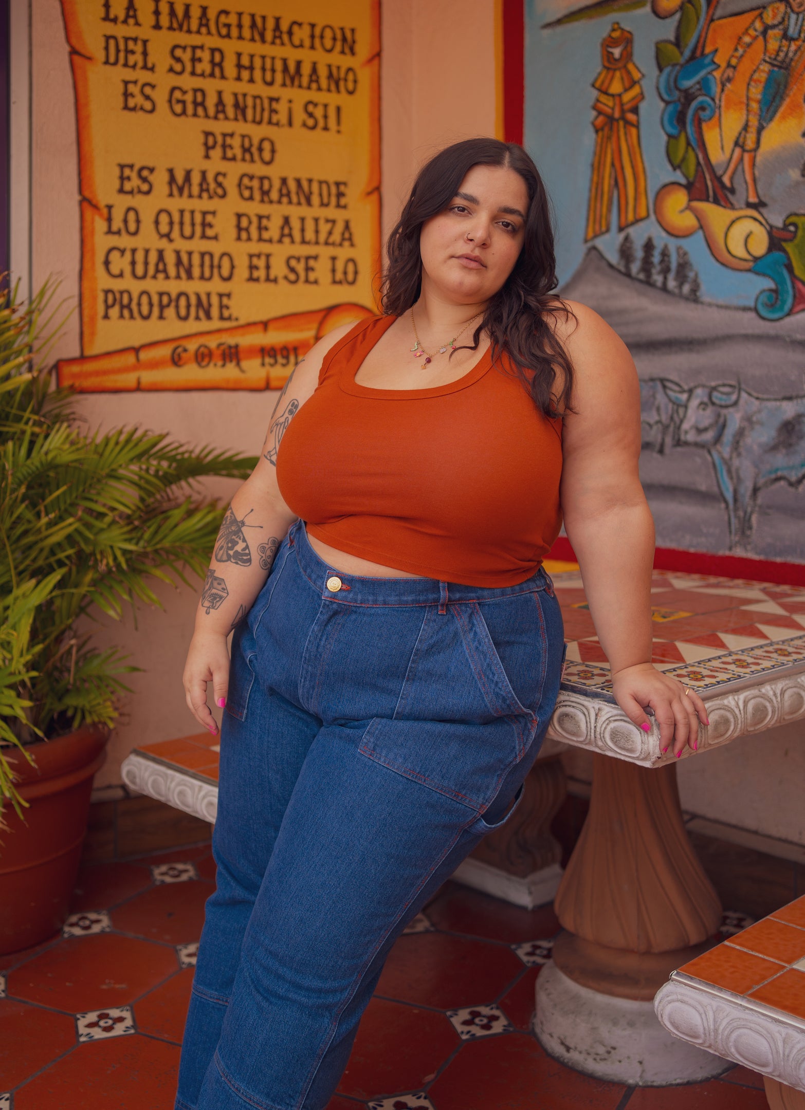 Carmen is wearing Cropped Tank Top in Burnt Terracotta and Carpenter Jeans in Dark Wash