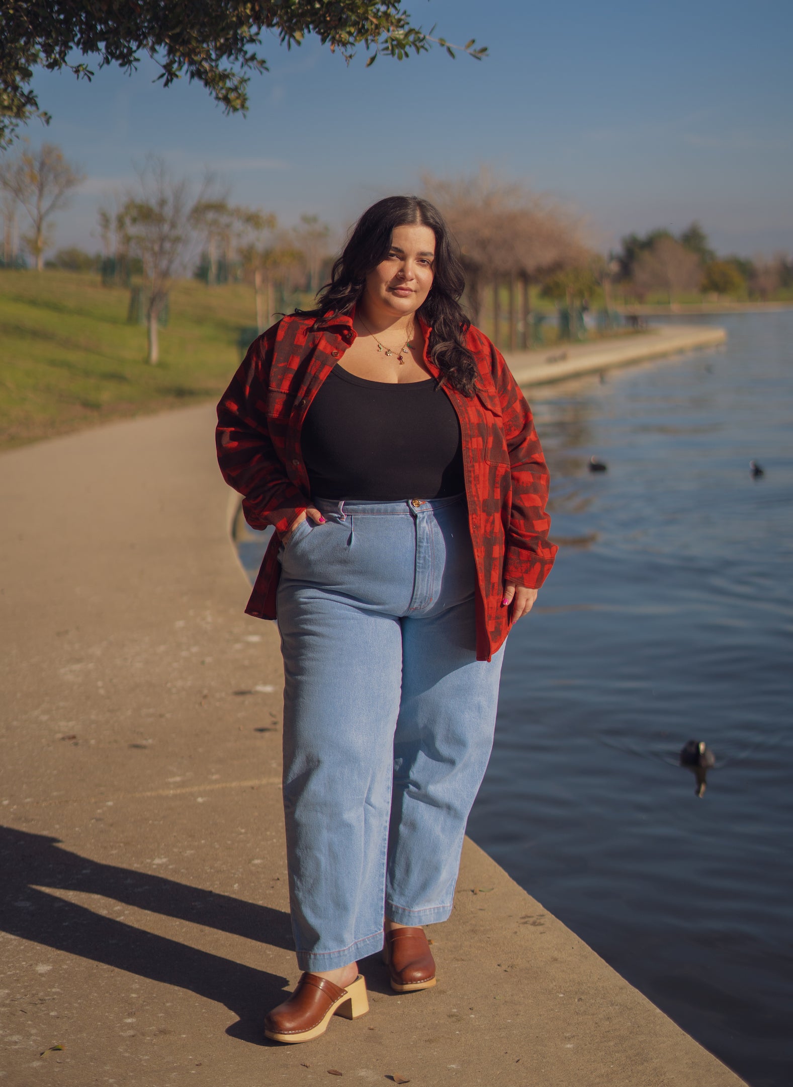 Carmen is wearing Plaid Flannel Overshirt in Paprika, Tank Top in Black and Denim Trousers in Light Wash