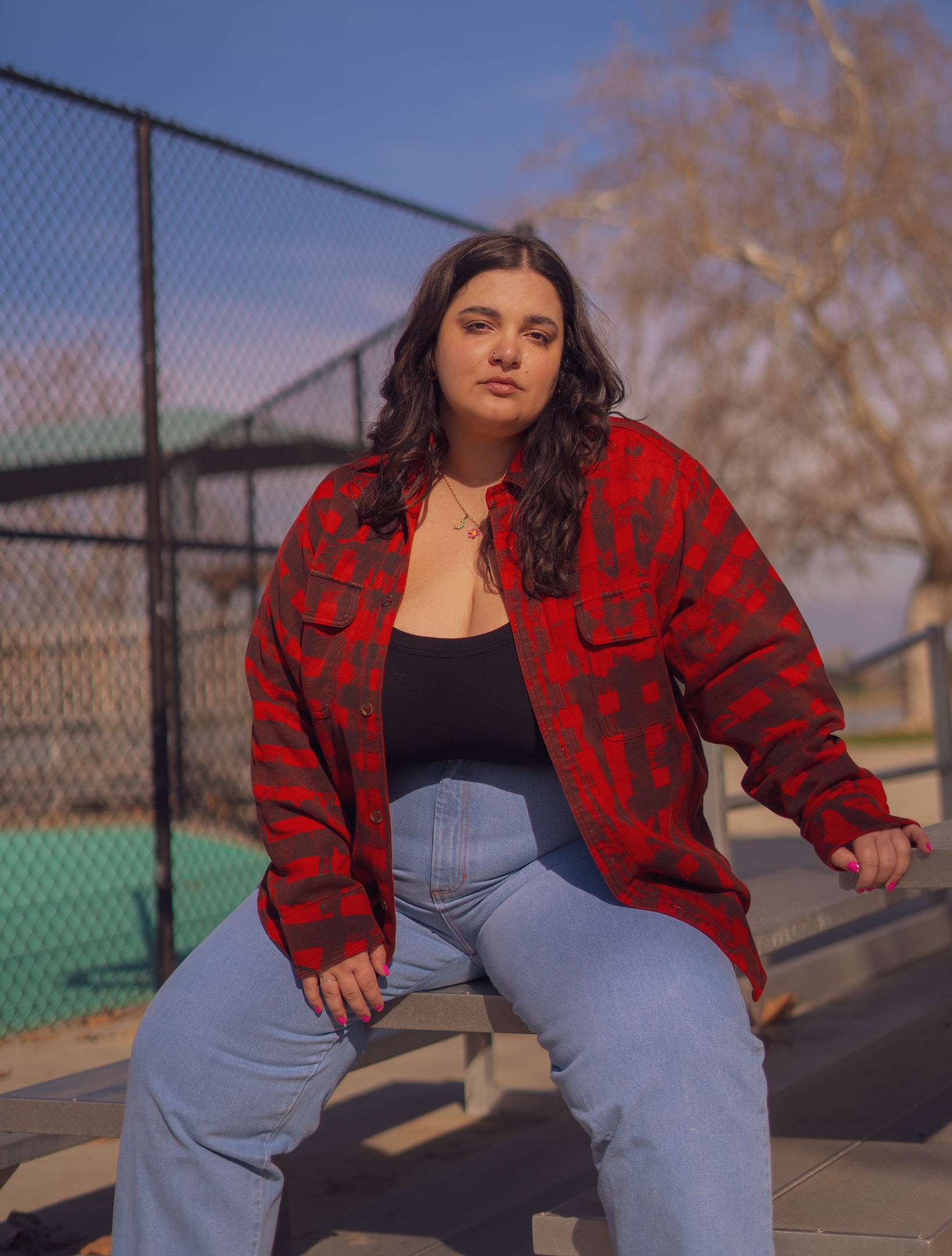 Carmen is wearing Plaid Flannel Overshirt in Paprika, Tank Top in Black and Denim Trousers in Light Wash