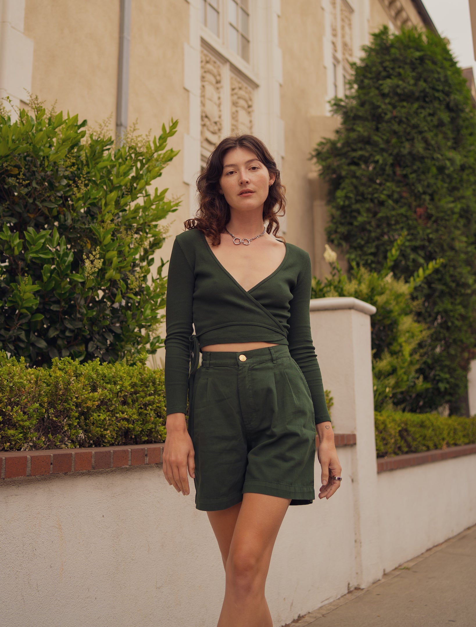 Alexandra Skye is wearing a Wrap Top in Swamp Green and Trouser Shorts in Swamp Green