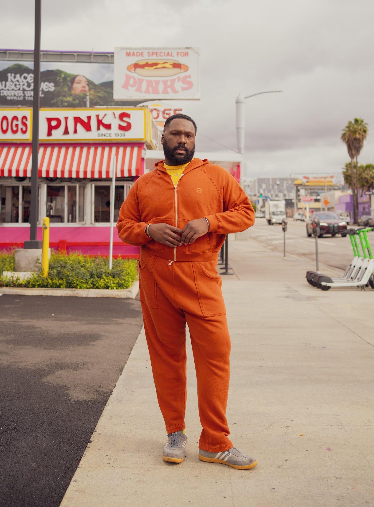 Elijah is wearing Cropped Zip Hoodie and Rolled Cuff Sweat Pants in Burnt Terracotta