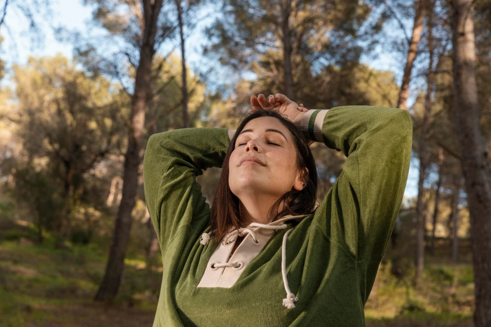 happy woman standing in nature, calming her mind and being in the moment