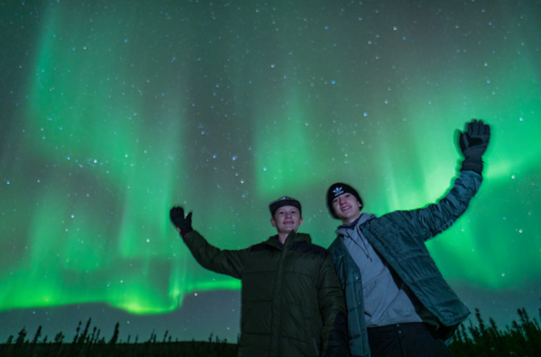 Tour guests waving and smiling on a northern lights adventure in Fairbanks, Alaska