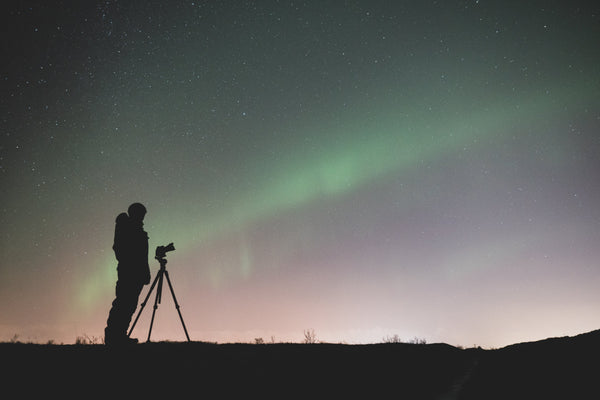 photographer taking photo of the aurora