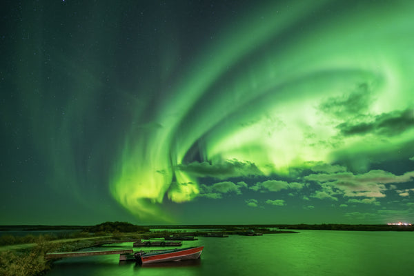 Aurora borealis reflecting off a lake in northern Canada in Churchill, Manitoba captured by Vincent Ledvina.