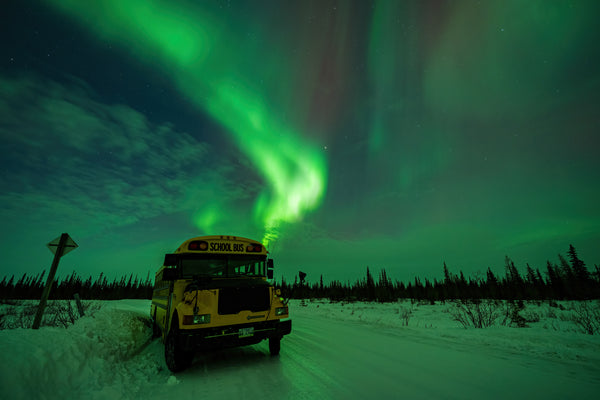 School bus underneath the aurora borealis in Churchill, Manitoba