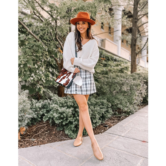 woman wearing plaid skirt, sweater, beige leather flats