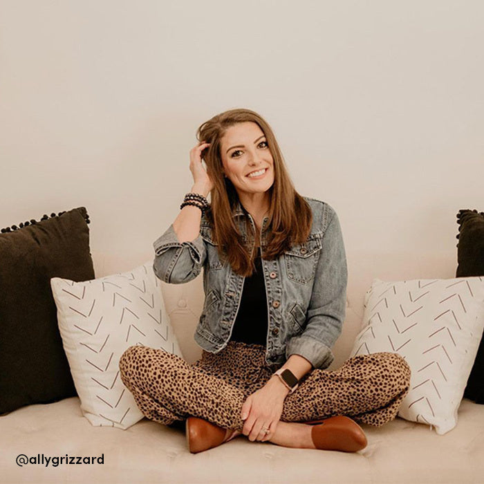 woman wearing cheetah pants, denim jacket, brown leather flats