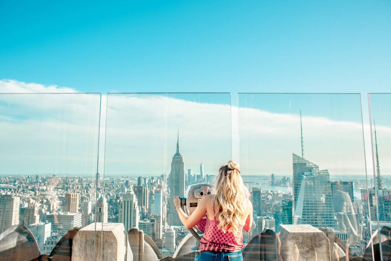 Woman in a spring vacation outfit admiring a cityscape view