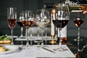 Red and white wine glasses arranged on a table.