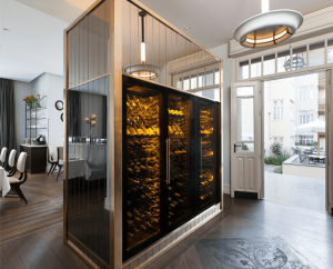 Wine cooler refrigerator positioned in the centre of an open room.