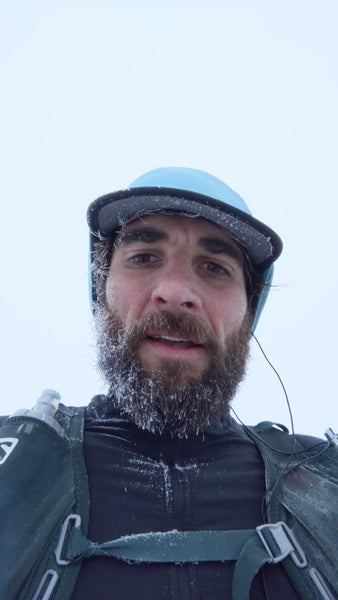 Logan Estop-Hall founder of The Feets running in snow with frozen beard