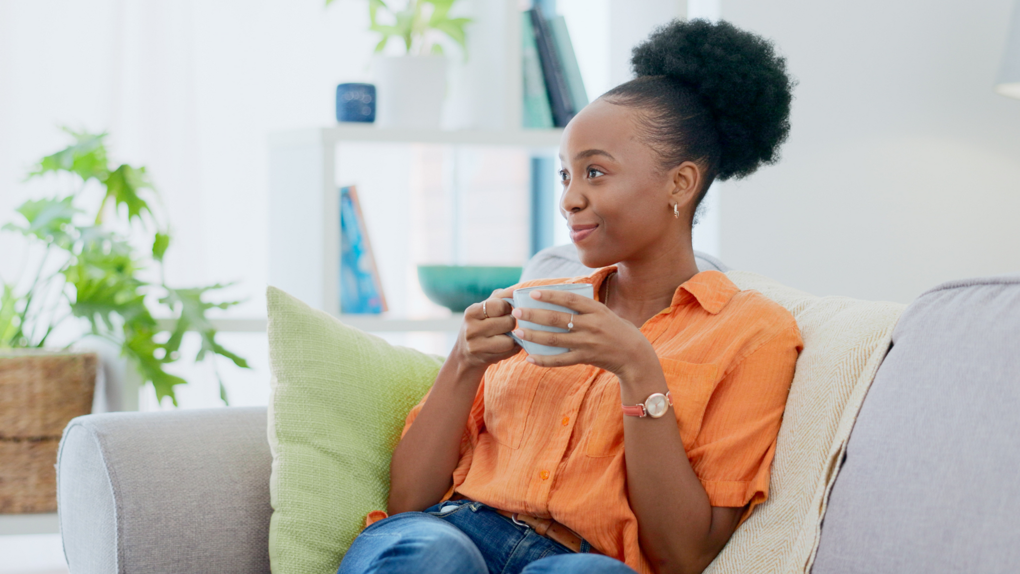 Woman sitting on sofa drinking a cup of tea