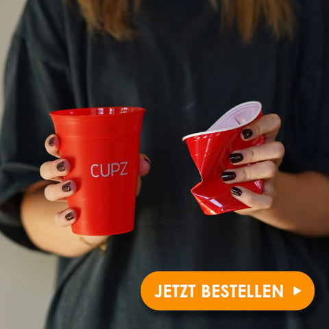 Wiederverwendbare rote Beerpong Becher in der Hand 