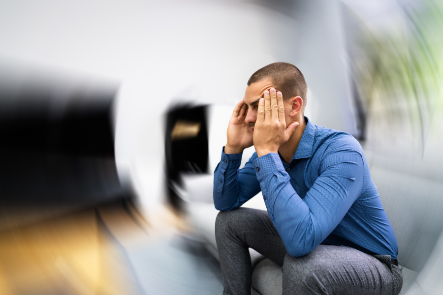 person suffering with vertigo on sofa