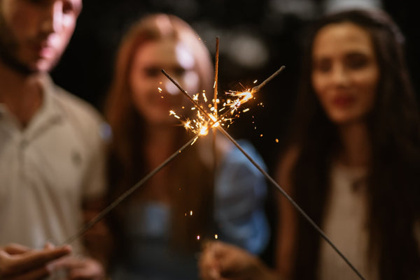 1 guy and 2 girls holding sparklers