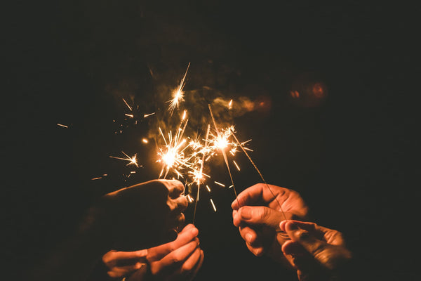 couple holding sparklers at night