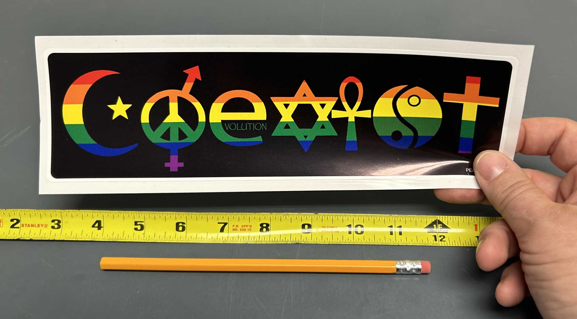 coexist bumper sticker in hand