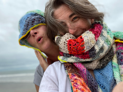 Sheri and Ladianne - Co-founders of WoolTribe, on a beach in North Carolina, wearing a scarf made of hand dyed yarn