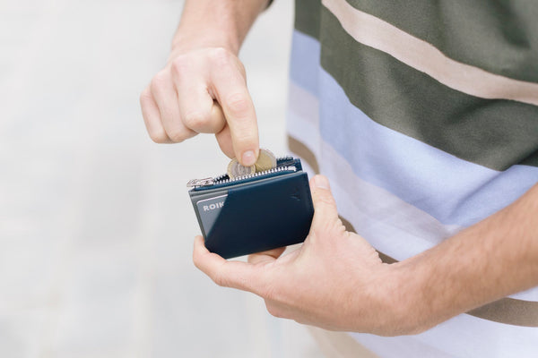 Hombre usando su cartera de piel que le regalaron en el Día del Padre.