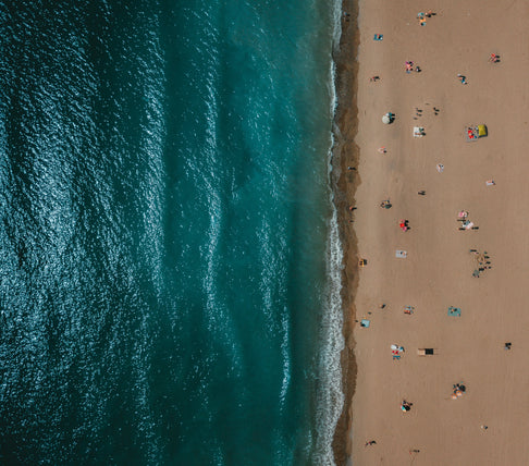 aerial-view-of-sandy-beach-scattered-with-sunbathers.jpg__PID:653fe675-d316-4026-b8fa-f8f2858ec61f