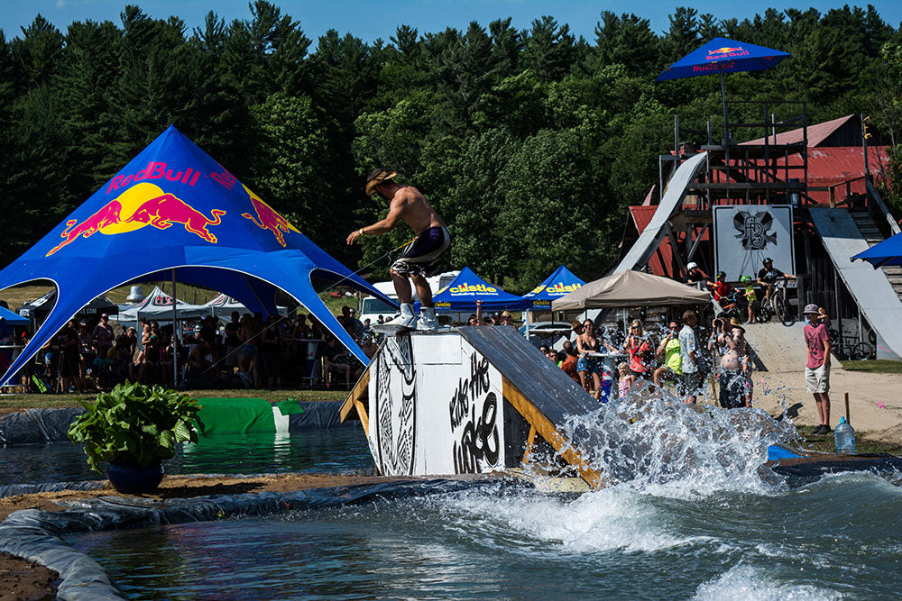 A wakeboarder is pulled by a winch to hit a feature going from pool to pool